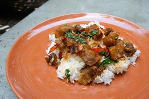 Most favorite and popular street food or homemade food of Thailand, Crispy pork belly with stir fried basil top on rice. It has a spicy, salty, sweet taste. Asian food. photo