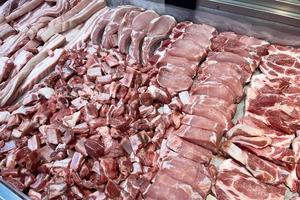 diferentes partes de la exhibición de carne de cerdo en el supermercado. carne fresca refrigerada y buen material de cocina. foto