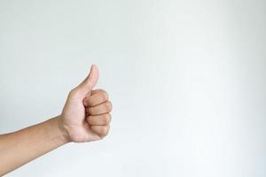 Closeup of asian male left hand showing thumbs up sign on white background photo