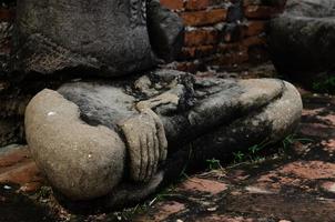 The ruins of the Buddha statue stolen by criminals. Ruins of Buddha statues in ancient sites, Famous tourist attraction in Ayutthaya Thailand. photo