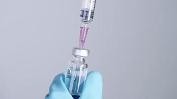 close-up agulha de injeção suga vacina médica líquida da garrafa, biotecnologia de drogas, frascos estéreis e equipamentos médicos, cura contagiosa pandêmica, remédio para problemas de saúde, pesquisa covid19 video