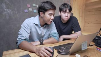 dos jóvenes ingenieros discutiendo razonablemente sobre el proyecto mientras estaban sentados en la oficina de casa, programador masculino activo explicando sus ideas a un colega, tecnología inalámbrica moderna que se usa en la vida diaria