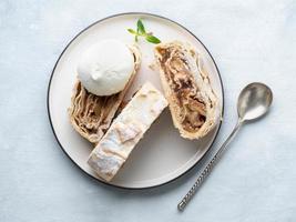 Apple strudel with ice cream and cinnamon. Baked cake, delicious dessert on the table. Top view photo