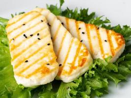 Grilled Halloumi, macro fried cheese with lettuce salad. Balanced diet, white plate, side view