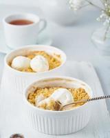 Apple crumble with ice cream, spoon with streusel. Side view, vertical. Morning breakfast photo