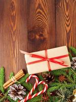 navidad y feliz año nuevo fondo marrón oscuro. caja de regalo de navidad, mesa de madera, vista superior, espacio de copia, vertical. foto