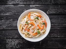 espaguetis de pasta italiana con camarones, salsa bechamel y eneldo picado foto