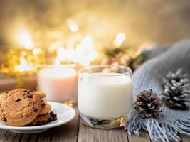Cozy evening, cup of drink, Christmas decorations, candles and lights garlands photo