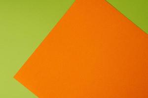 Orange and green colored background of layered cardboard sheets, top view, copy space photo
