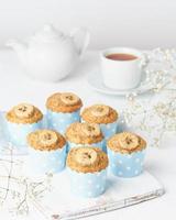 muffin de plátano, cupcakes en cajas de papel para pasteles azules, mesa de hormigón blanco, vertical, vista lateral