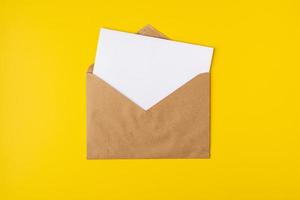 Realistic mockup blank white letter craft paper envelope on yellow backdrop front view, template photo