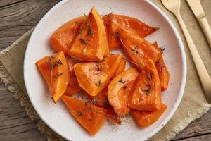 roasted pumpkin, pieces in plate with honey and seasonings photo