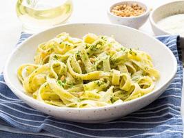 pasta tagliatelle con salsa pesto hecha de albahaca, ajo, piñones, aceite de oliva foto