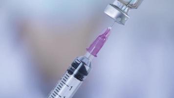 close-up médico enfermeiro usar agulha de injeção de seringa sugando remédio líquido da garrafa, vacina de biotecnologia de medicamentos, frascos estéreis e equipamentos médicos, conceito de cura de cura pandêmica