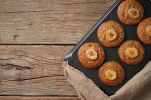 Banana muffin in tray, top view, copy space. Cupcakes on old linen napkin, photo