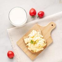 Sandwich with pan-fried scrambled eggs on wooden cutting board, top view. photo