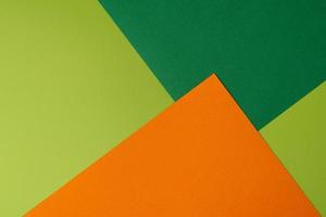 Colorful overlapped orange and green cardboard layers of paper on background, top view photo