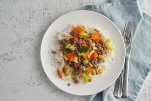 Delicious rice pasta with mince meat and vegetables, top view photo