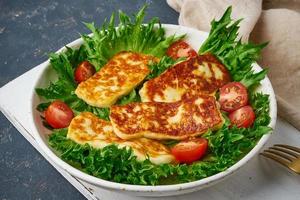 Healthy salad with fried halloumi and tomatoes, closeup, keto ketogenic diet photo