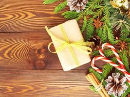 navidad y feliz año nuevo fondo marrón oscuro. caja de regalo de navidad, ramas de abeto