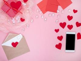 regalo en caja de regalo roja con lazo, teléfono inteligente, sobre, tarjeta, corazón rojo, fondo rosa, foto