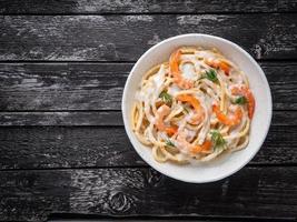 espaguetis de pasta italiana con camarones, salsa bechamel y eneldo picado foto