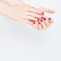 woman showing manicures hands with red nail polish on white background copy space photo