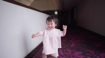 Asian baby having fun playing and waling toward camera, little girl laughing, child development skill learning age, pure innocence, healthy happy funny asian kids smiling in slow motion video