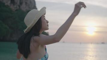 uma linda mulher de cabelo preto desfrutando de uma paisagem marinha natural na vibração da noite antes de sair, após a atividade de banho de sol, viagem de verão, indo para o mar no fim de semana, vestindo um biquíni fofo na praia video