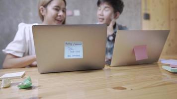 Zwei Bürounternehmer diskutieren über die Arbeit und geben Ratschläge, während sie mit einem Laptop arbeiten, um Informationen zu sammeln, die am Schreibtisch im Remote-Heimbüro sitzen, Teamarbeit, die die Unternehmensentwicklung erklärt video