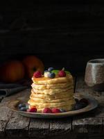 Pancake with butter, blueberries and raspberries. Side view, copy space photo
