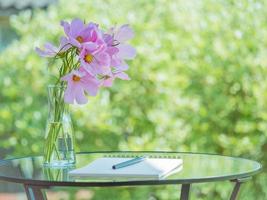 Notebook, pen on table in Park garden, bouquet of flowers, empty space. Concept for thinking photo