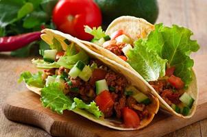 Mexican tacos with meat, vegetables and cheese photo