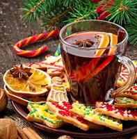 Warming mulled wine, spices and gingerbread cookie on a wooden background in rustic style photo