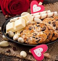 White chocolate, almonds and cookies on a wooden background photo