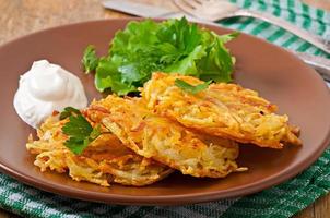 tortitas de patata aromáticas con crema agria y hierbas foto