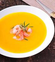 Pumpkin soup with shrimp and rosemary photo