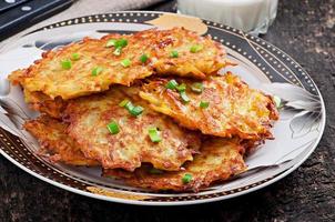 Fried potato pancakes on the old wooden background photo