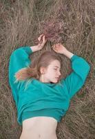 Young woman in fields, portrait of beautiful female relaxing in dry grass photo