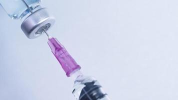 gros plan sur un vaccin liquide médical passe du flacon à la seringue, médicament en flacon, prêt pour l'injection de vaccin, administration du système sérique, distribution du vaccin contre le coronavirus, système d'immunité collective video