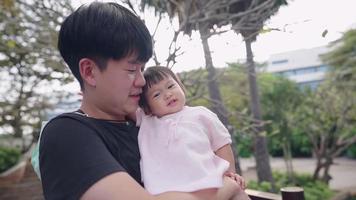 un jeune père asiatique tient son innocence petite fille passant du temps ensemble au parc, développement du jeune âge du nourrisson, lien familial père et fille, se tenant à distance des personnes à distance sociale