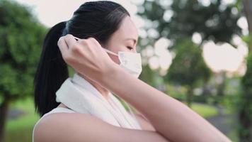 Young asian woman remove face mask before exercise, infectious diseases protection awareness, risk management, stay healthy during pandemic covid19 corona virus distancing. carefree risk in public video
