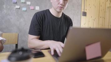 junger mann, der mit laptop-computer im arbeitsbereich des heimbüros arbeitet, anrufe von kunden erhält, teamkollege bei distanzierungsquarantänetreffen, multitasking-mann und moderne technologie