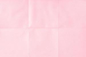 fondo de textura de hoja de papel desplegado arrugado rosa. papel doblado en seis. fotograma completo foto