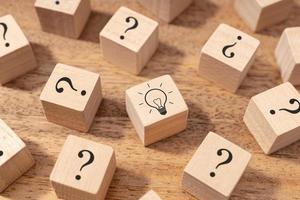 Creative idea and innovation concept. Wooden blocks with question mark symbol and light bulb photo