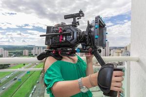 Young woman operating film camera photo