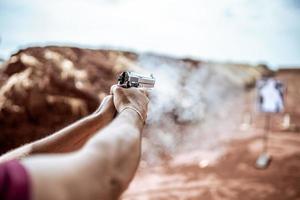 Detail view of shooter holding gun and training tactical shooting, focus on pistol. Shooting range. photo