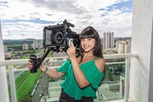 mujer joven operando cámara de cine foto