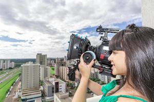 mujer joven operando cámara de cine foto