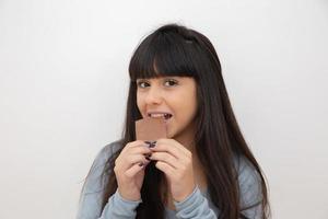 mujer joven comiendo chocolate foto